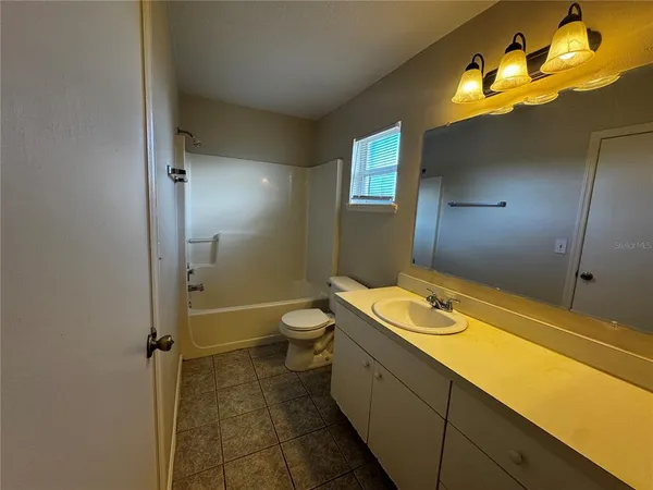 a bathroom with a sink and mirror with toilet