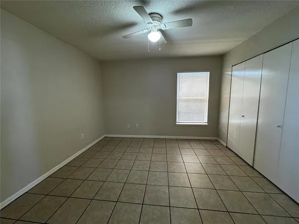 a view of an empty room and window chandelier fan