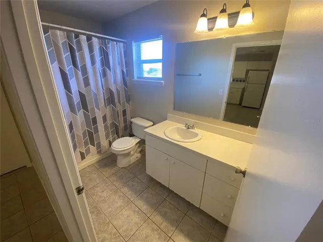 a bathroom with a sink a toilet and shower curtain