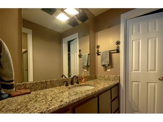 2529 Rio Grande Street, Unit 69 Austin, TX 78705 - Photo 12 of 25 a bathroom with a granite countertop sink and a mirror