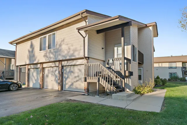 a view of a house with a small yard and wooden fence