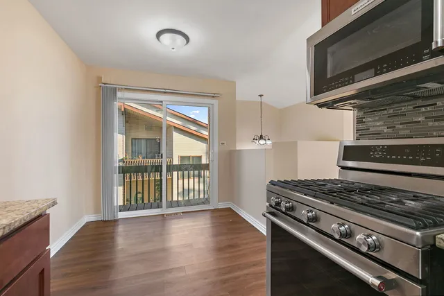 a kitchen with wooden floor and a stove top oven