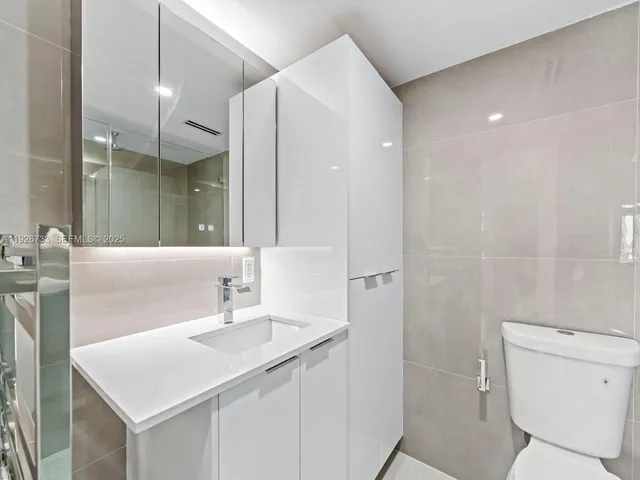 a bathroom with a sink toilet vanity and shower