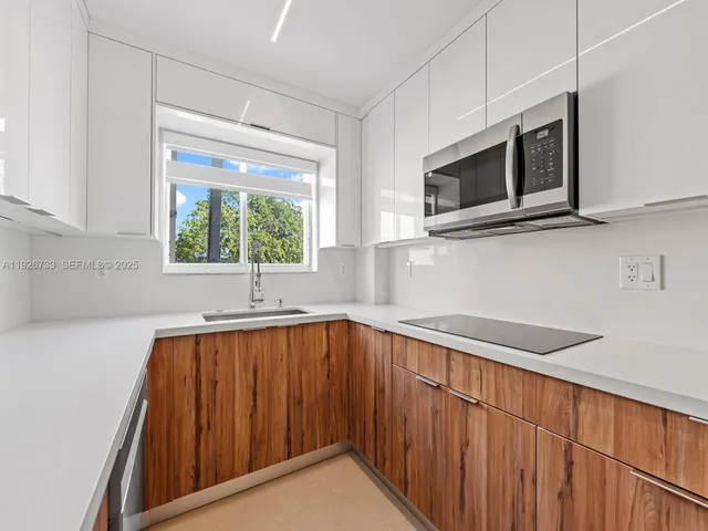 a kitchen with stainless steel appliances a microwave sink and cabinets