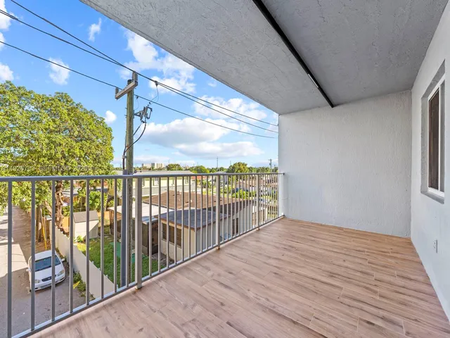 a view of a hallway with wooden floor and entryway