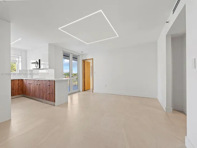 a large white kitchen with a sink and cabinets