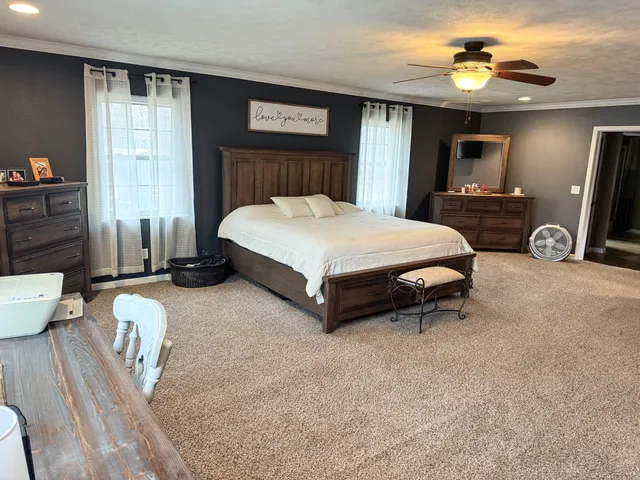 a spacious bedroom with a bed and a chandelier