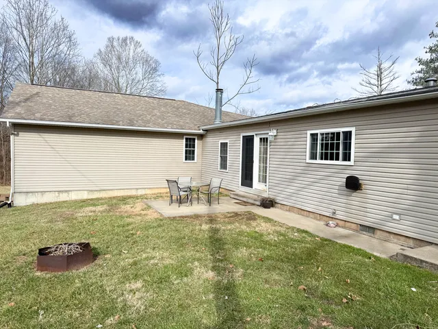 a backyard of a house with table and chairs