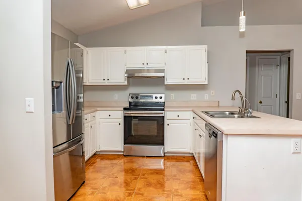 a kitchen with a stove sink and a refrigerator