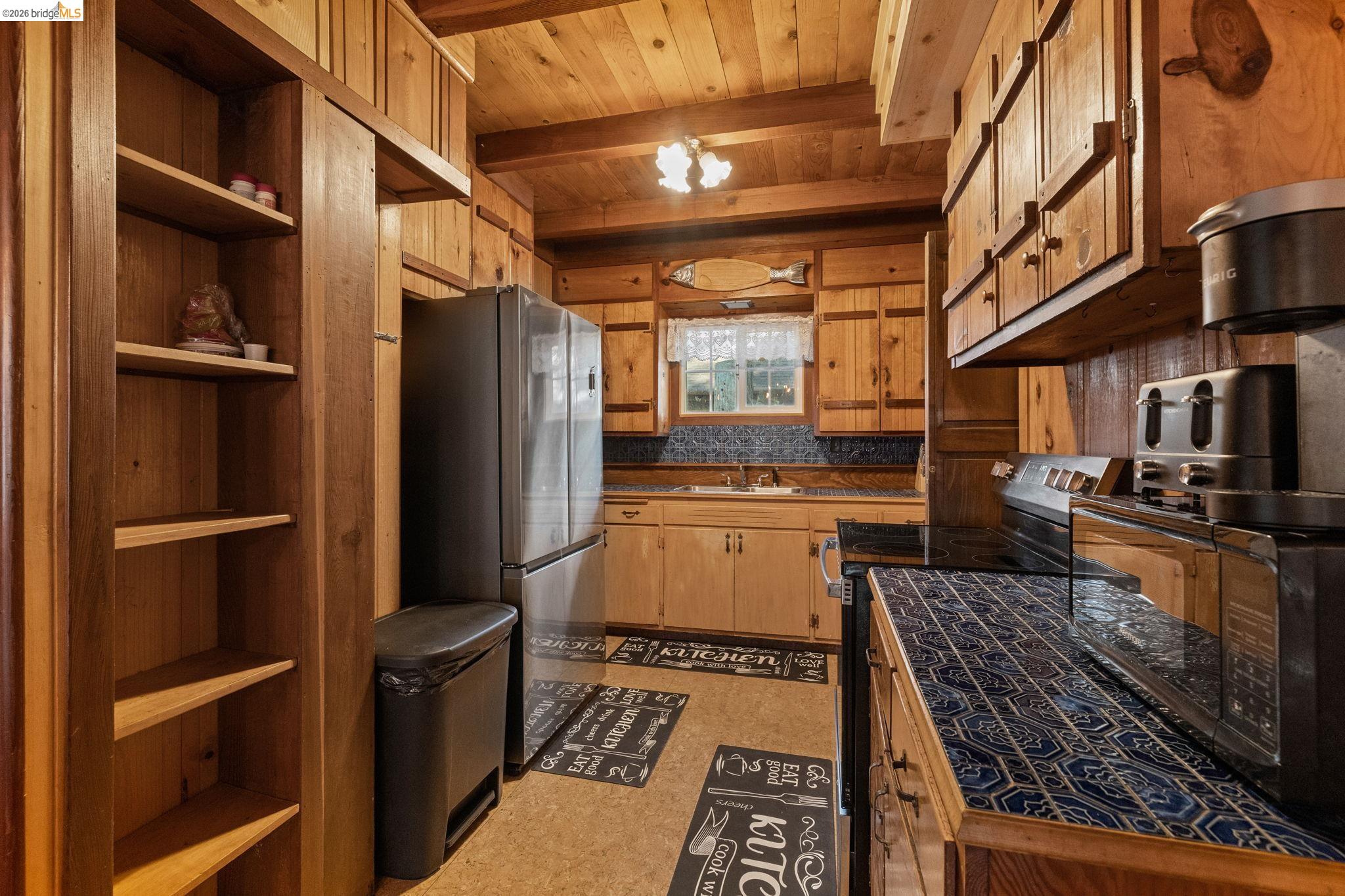 26175 Janice Way Long Barn, CA 95335 - Photo 7 of 23 Kitchen featuring electric range, open shelves, freestanding refrigerator, decorative backsplash, and a wooden ceiling with exposed beams