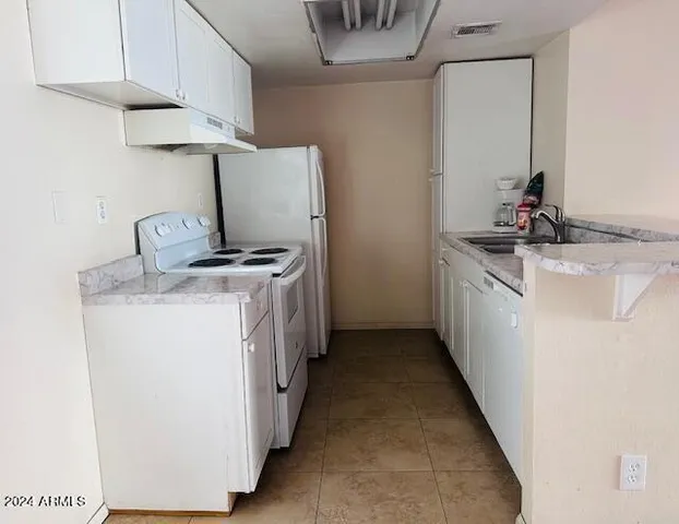 a utility room with cabinets washer and dryer