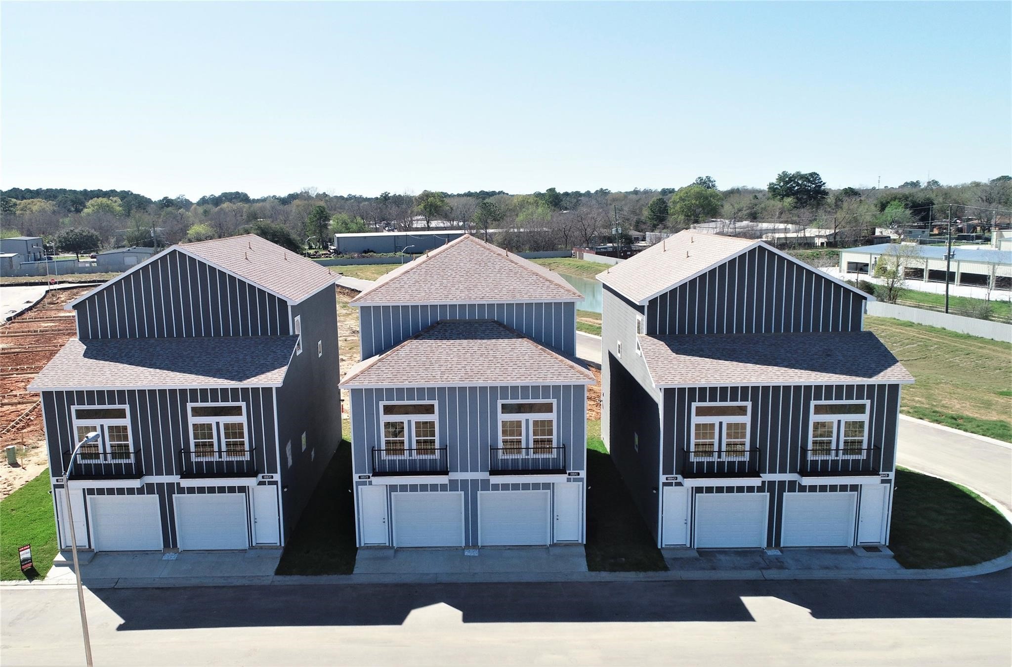Modern two-story homes with gray siding and white trim, featuring attached garages and large front windows.