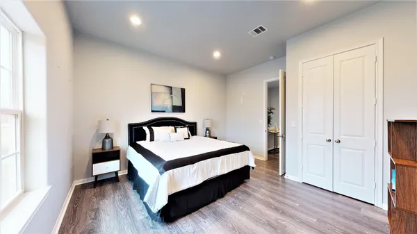 a white bed sitting in a spacious bedroom next to a window