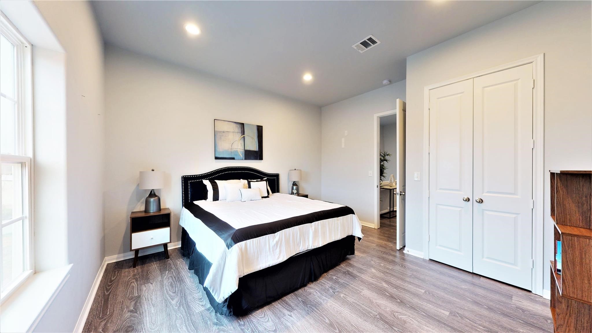 4924 Paradigm Ln Spring Spring, TX 77379 - Photo 12 of 18 This bedroom features a spacious layout with sleek hardwood flooring and ample natural light. The neutral walls and recessed lighting create a cozy, inviting atmosphere.
