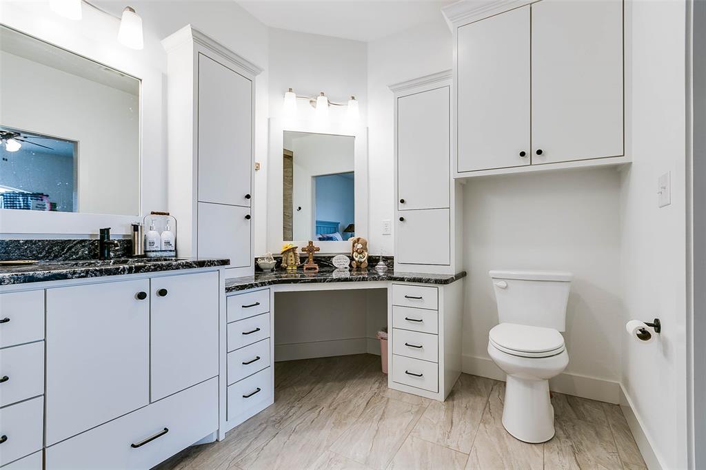 12487 County Road 4102 Hermleigh, TX 79526 - Photo 11 of 40 a bathroom with a granite countertop toilet sink and mirror