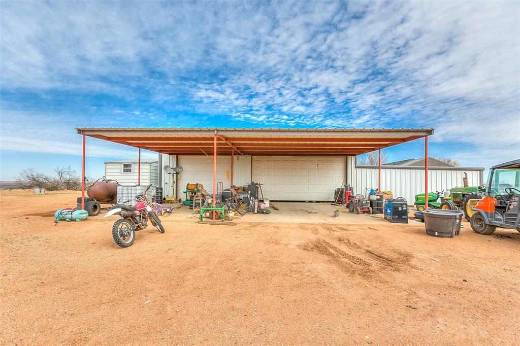 12487 County Road 4102 Hermleigh, TX 79526 - Photo 34 of 40 a view of a backyard with a table and chairs under an umbrella