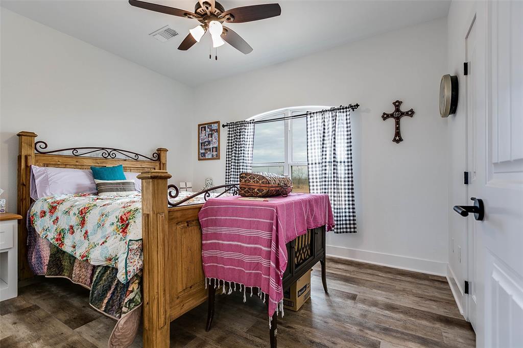 12487 County Road 4102 Hermleigh, TX 79526 - Photo 8 of 40 a bedroom with a bed and a chandelier