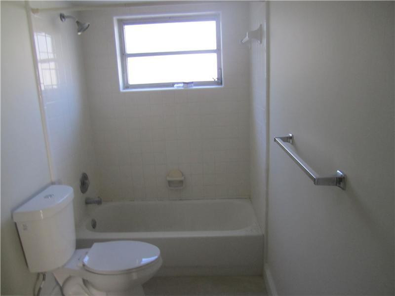 6320 Southwest 6th Street Margate, FL 33068 - Photo 7 of 8 a white toilet and tub next to a window