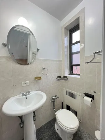 a bathroom with a toilet a sink and mirror