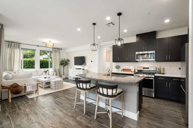 a kitchen with stainless steel appliances granite countertop a stove refrigerator and a microwave