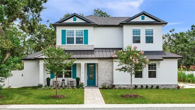 a front view of a house with a yard and trees