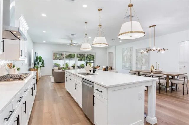 a living room with furniture kitchen view and a chandelier