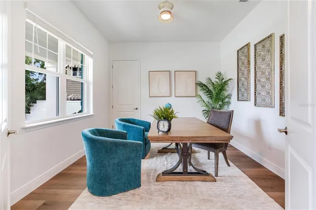 a view of a dining room and livingroom with furniture wooden floor a chandelier