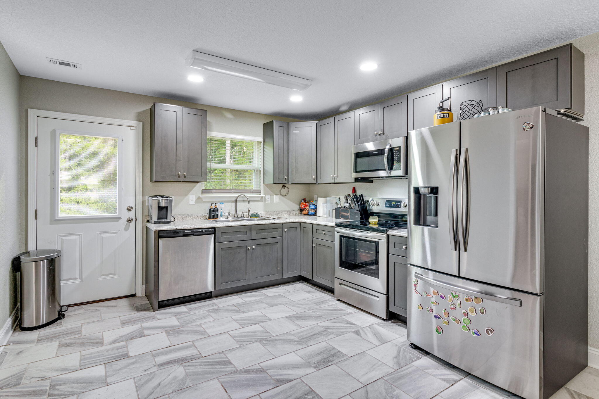 107 Eastview Drive Crestview, FL 32536 - Photo 11 of 23 a kitchen with granite countertop a refrigerator and a stove top oven