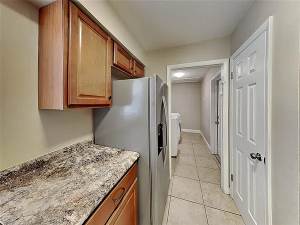a kitchen with kitchen island granite countertop a refrigerator and cabinets
