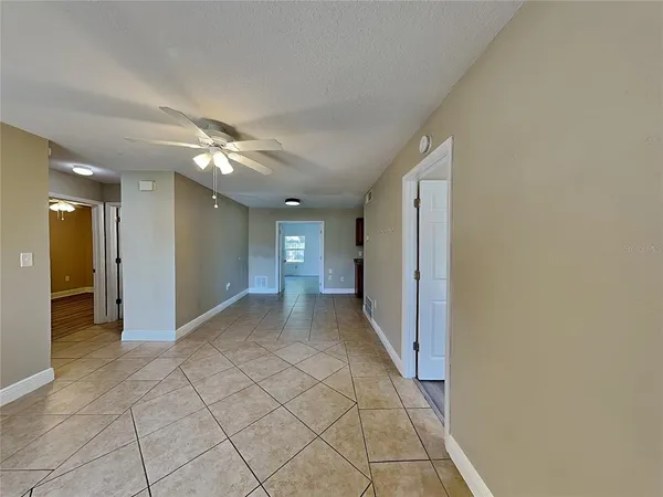 a view of a hallway with wooden floor and chandelier in a room