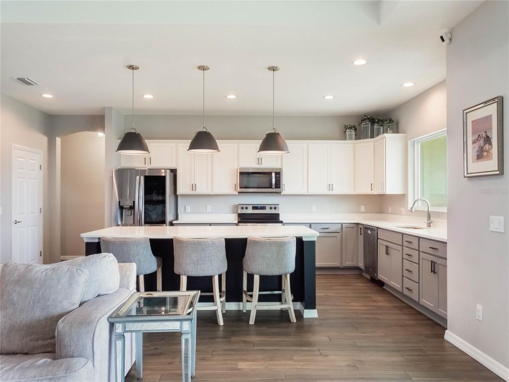 4735 Northwest 11th Court Ocala, FL 34475 - Photo 11 of 34 a large kitchen with cabinets chairs and wooden floor