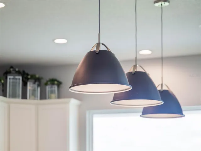 a kitchen with stainless steel appliances granite countertop a sink a stove a refrigerator cabinets and chairs