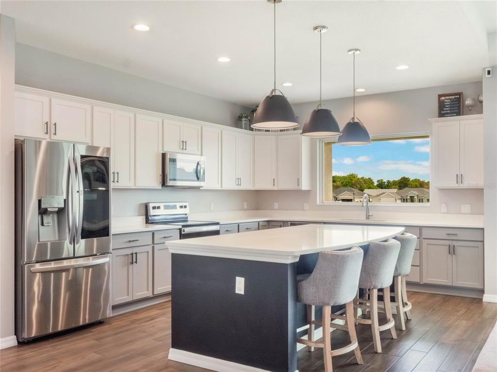 4735 Northwest 11th Court Ocala, FL 34475 - Photo 13 of 34 a kitchen with stainless steel appliances granite countertop a sink a stove a refrigerator cabinets and chairs