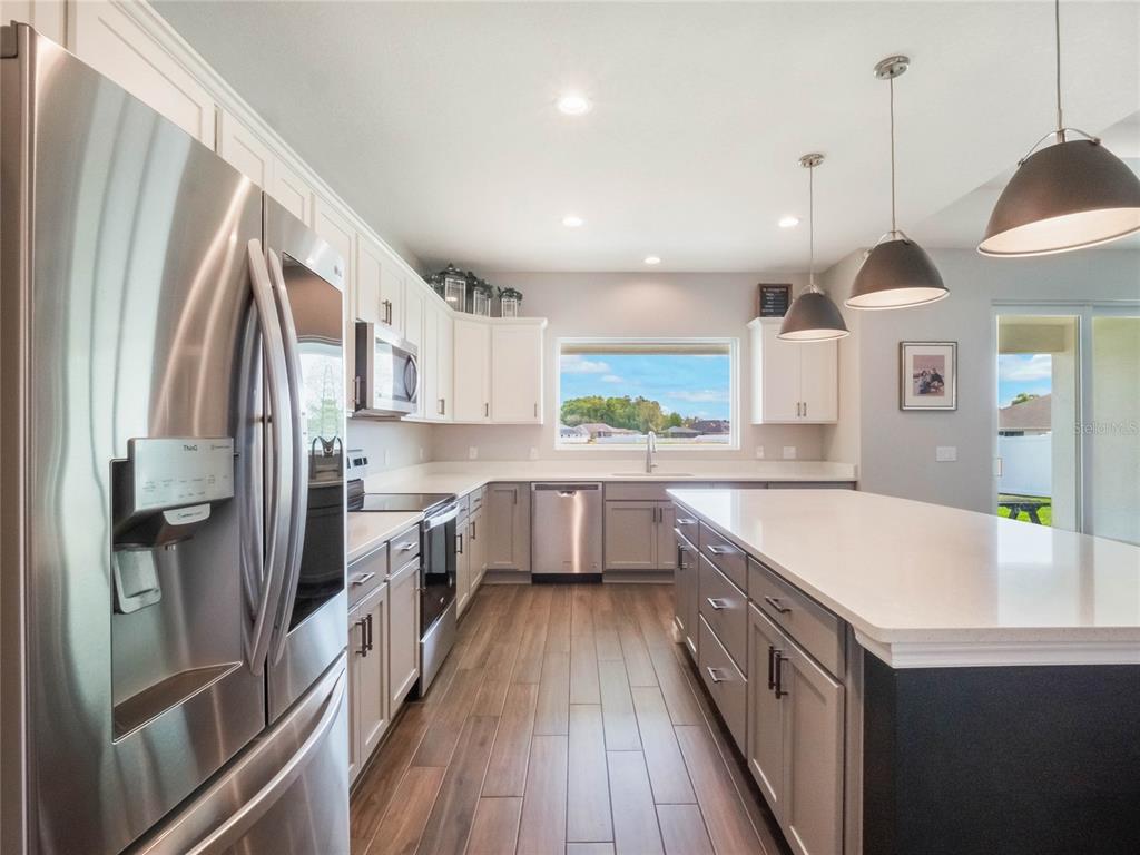 4735 Northwest 11th Court Ocala, FL 34475 - Photo 15 of 34 a kitchen with a sink a counter top space stainless steel appliances and a window