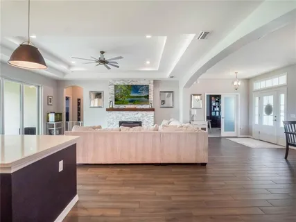 a kitchen with stainless steel appliances granite countertop a sink a stove and a wooden floors
