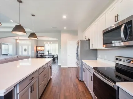 a spacious bedroom with a bed and a chandelier