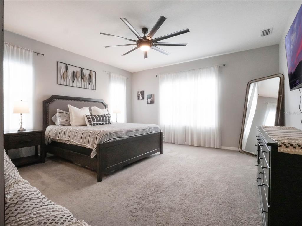 4735 Northwest 11th Court Ocala, FL 34475 - Photo 18 of 34 a spacious bedroom with a bed and a chandelier