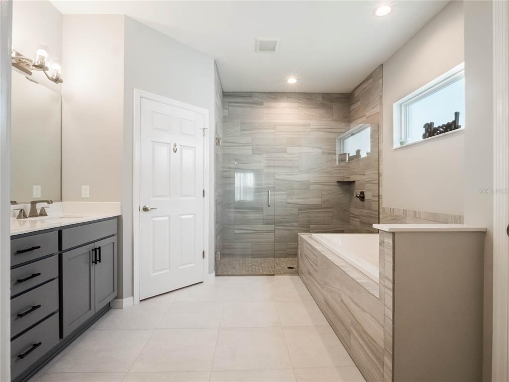 4735 Northwest 11th Court Ocala, FL 34475 - Photo 21 of 34 a bathroom with a double vanity sink a toilet and shower