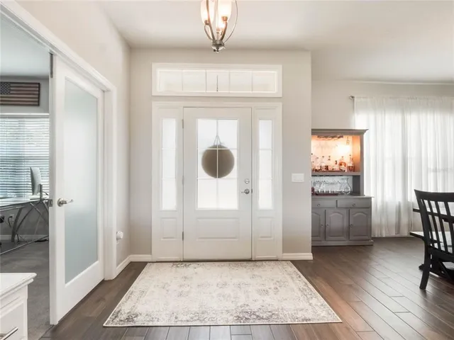 a view of a hallway to a livingroom with furniture and windows