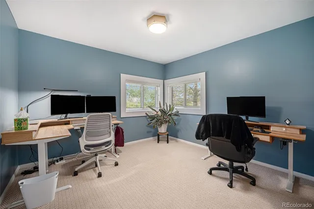 a view of a workspace with furniture and a window