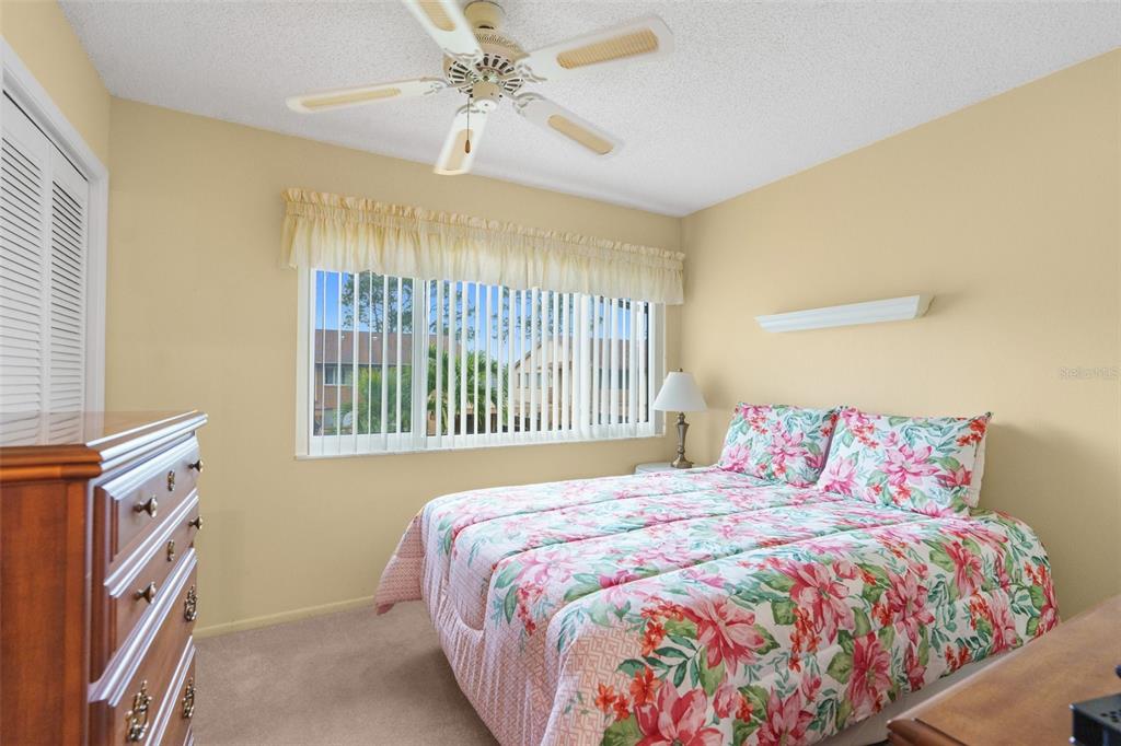 4445 Pelorus Drive New Port Richey, FL 34652 - Photo 16 of 26 a bedroom with a bed and a chandelier