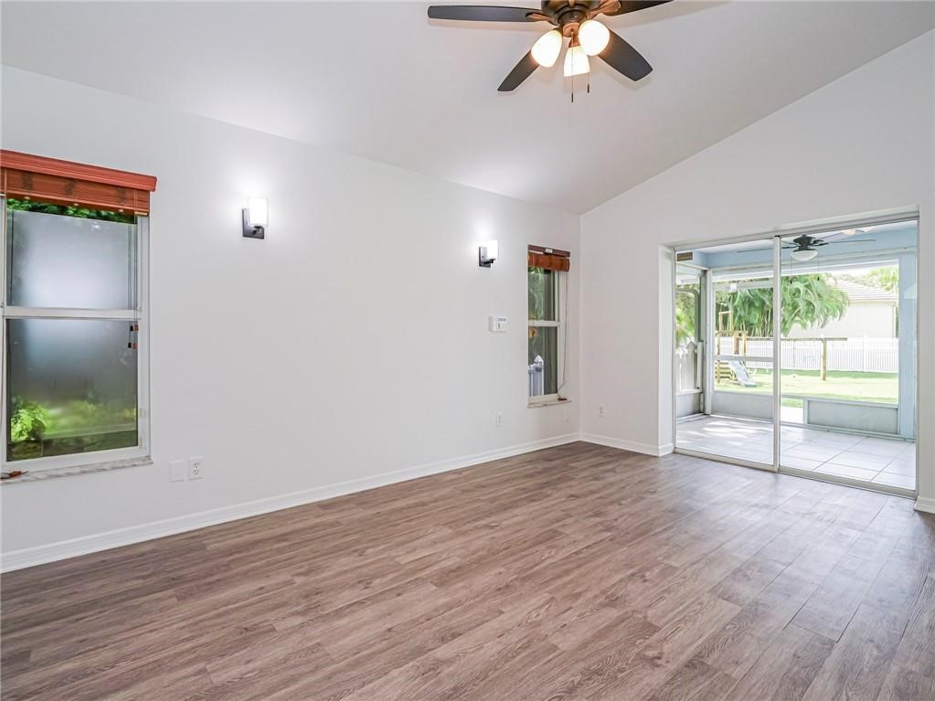 6445 55th Square Vero Beach, FL 32967 - Photo 11 of 36 a view of an empty room with wooden floor and a window