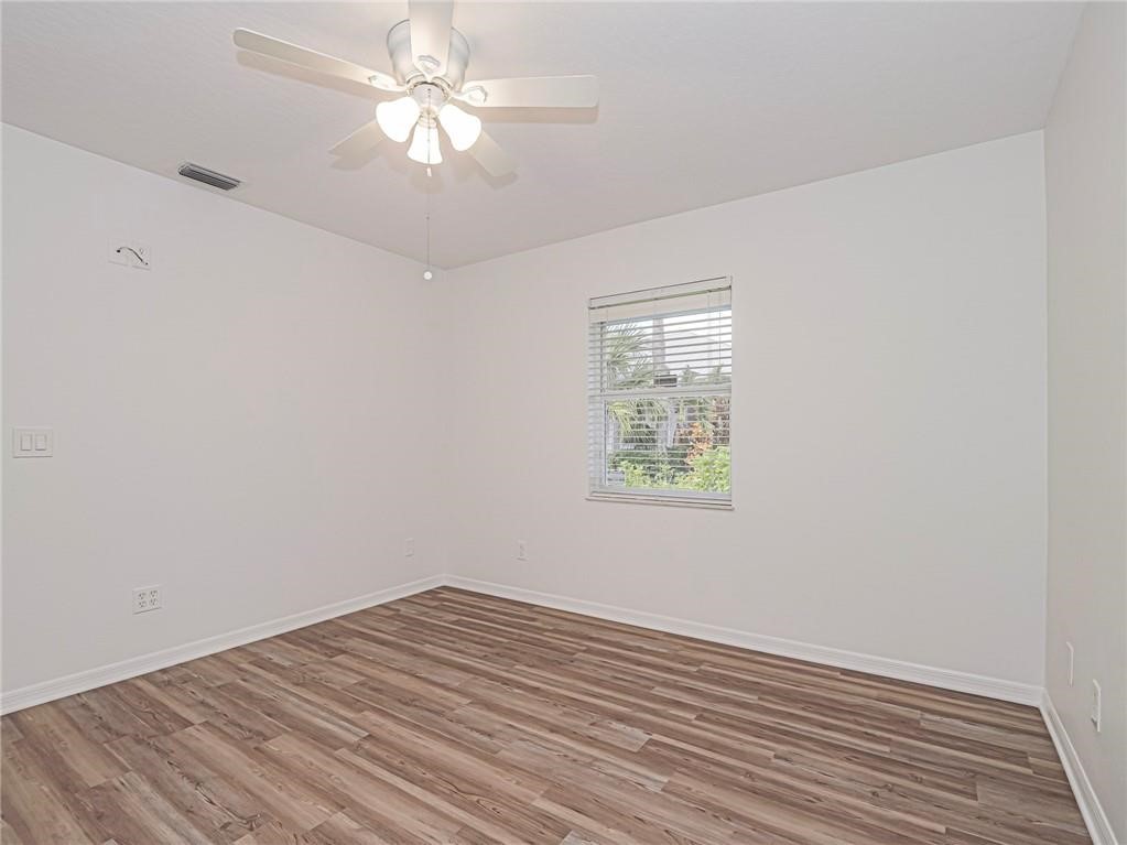6445 55th Square Vero Beach, FL 32967 - Photo 16 of 36 wooden floor in an empty room with a window