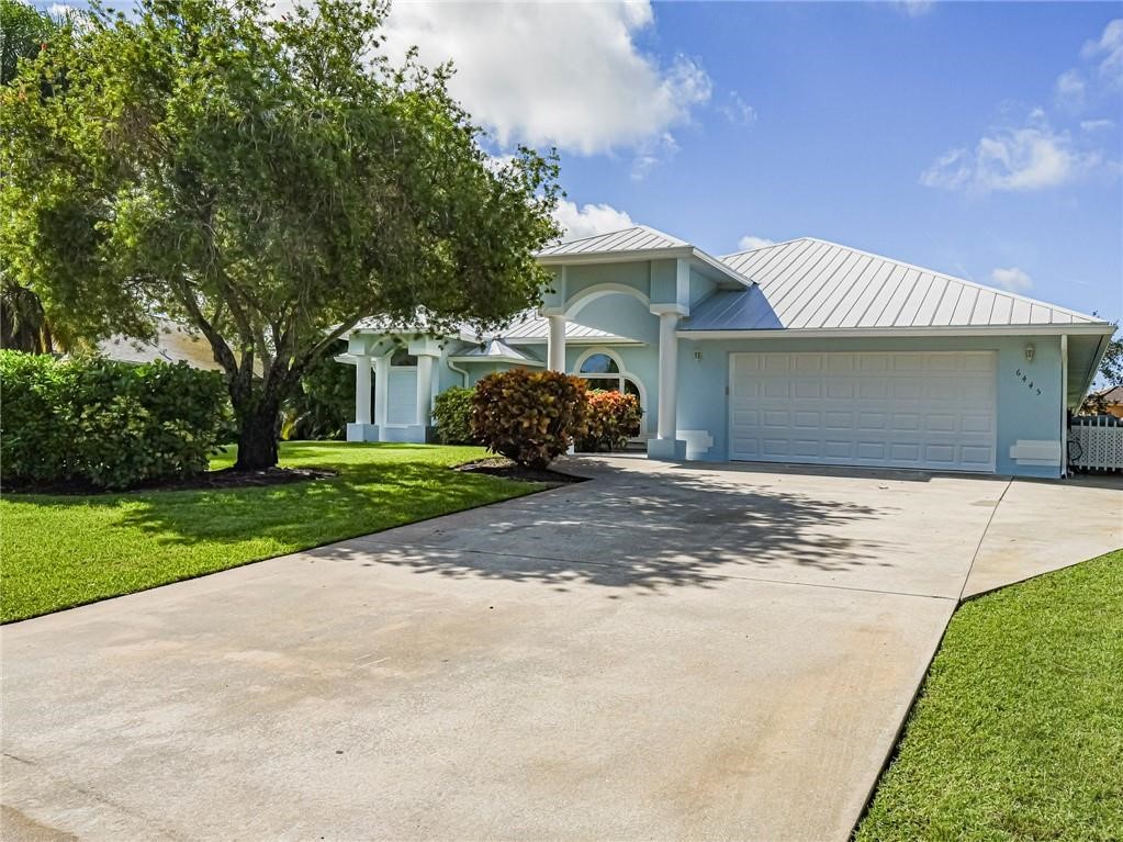 6445 55th Square Vero Beach, FL 32967 - Photo 2 of 36 a front view of a house with a yard and garage