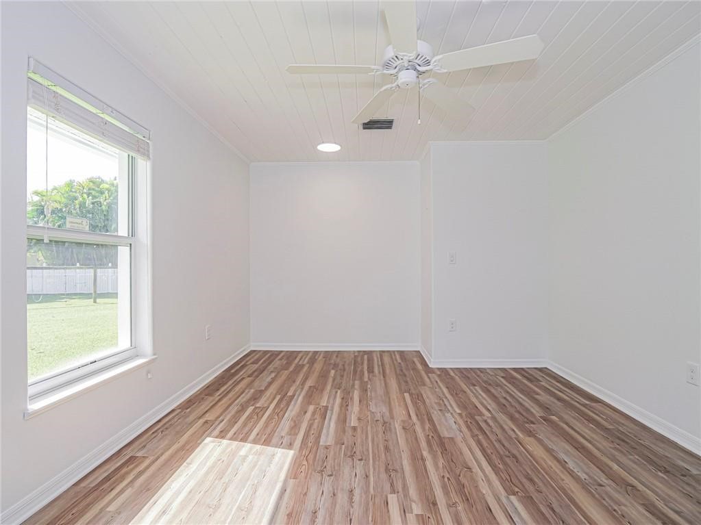 6445 55th Square Vero Beach, FL 32967 - Photo 21 of 36 wooden floor in an empty room with a window