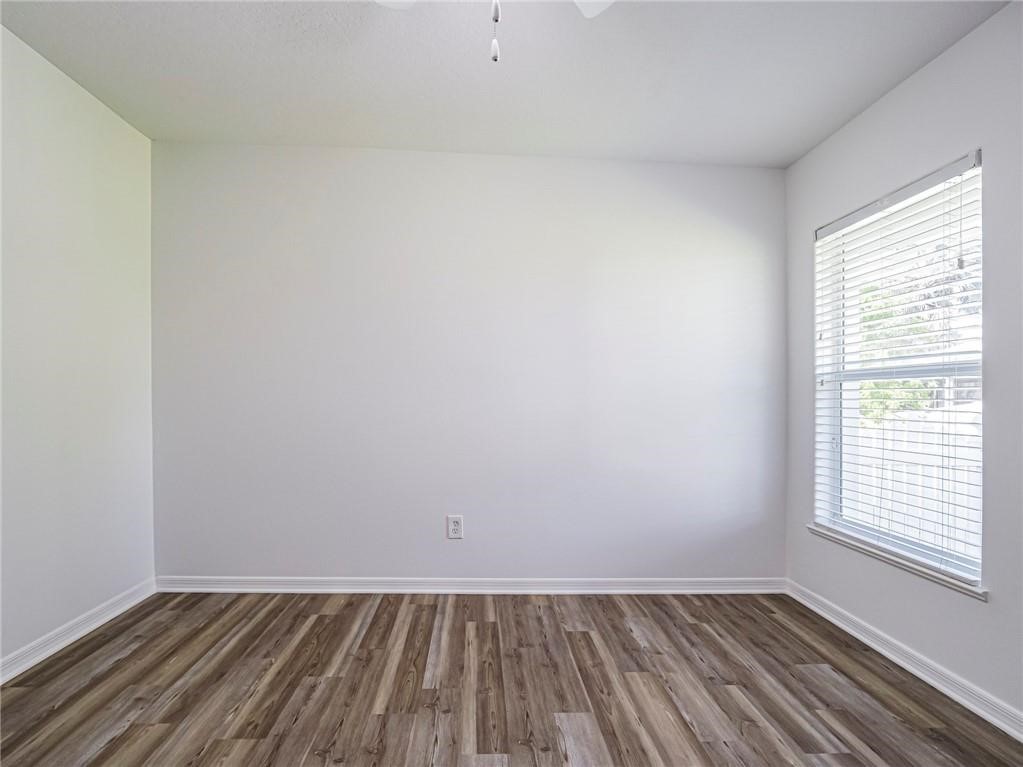 6445 55th Square Vero Beach, FL 32967 - Photo 21 of 36 an empty room with wooden floor and windows