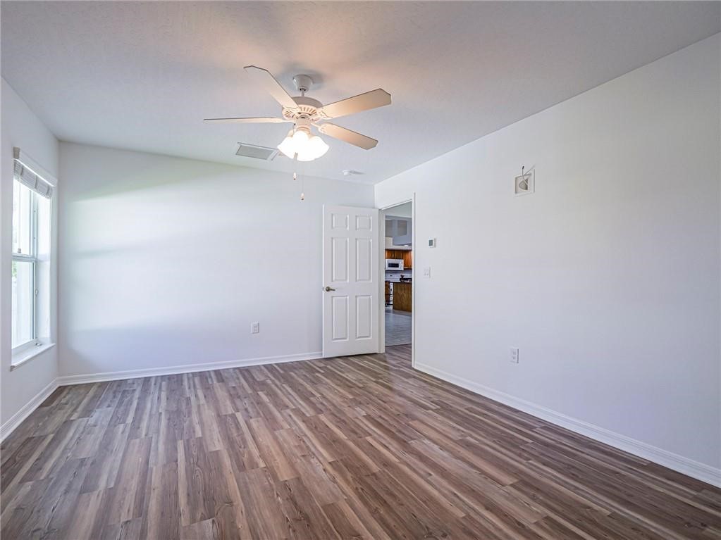 6445 55th Square Vero Beach, FL 32967 - Photo 29 of 36 wooden floor in an empty room with a window