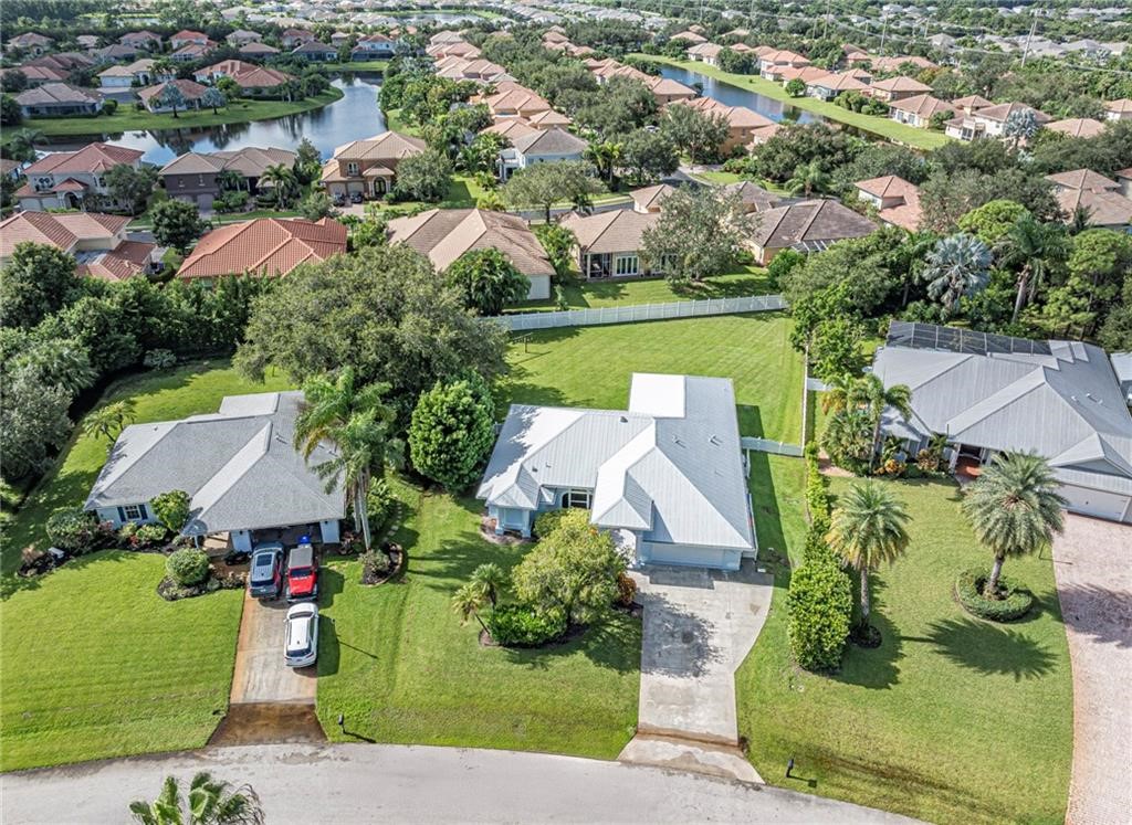 6445 55th Square Vero Beach, FL 32967 - Photo 3 of 36 an aerial view of a house with a yard and lake view