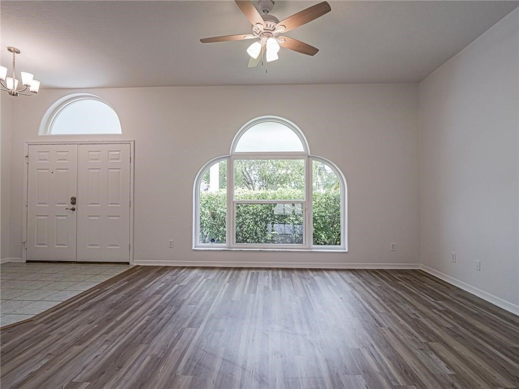 6445 55th Square Vero Beach, FL 32967 - Photo 5 of 36 wooden floor in an empty room with a window
