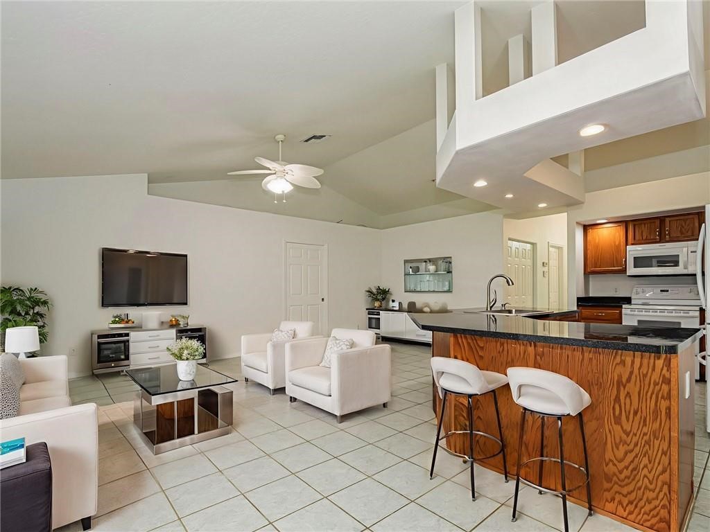 6445 55th Square Vero Beach, FL 32967 - Photo 6 of 36 a living room with furniture and a flat screen tv